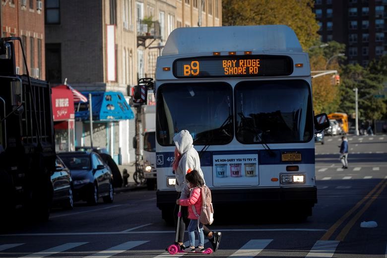 A woman walks her child to school during the outbreak of the coronavirus disease (COVID-19) in the Bay Ridge area of Brooklyn, New York, U.S., October 8, 2020. REUTERS/Brendan McDermid